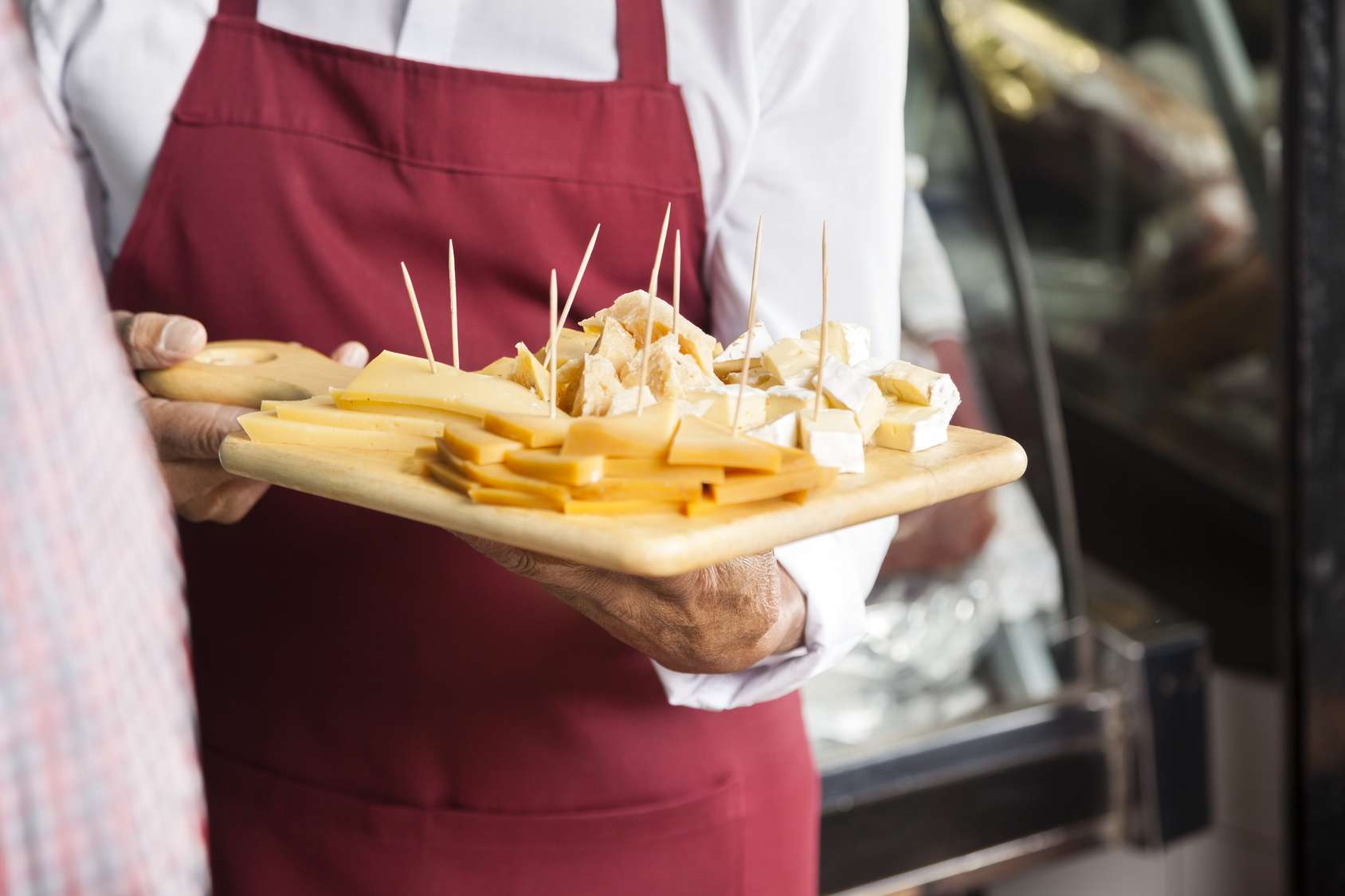 Salesman Holding Cutting Board With Assorted Cheese